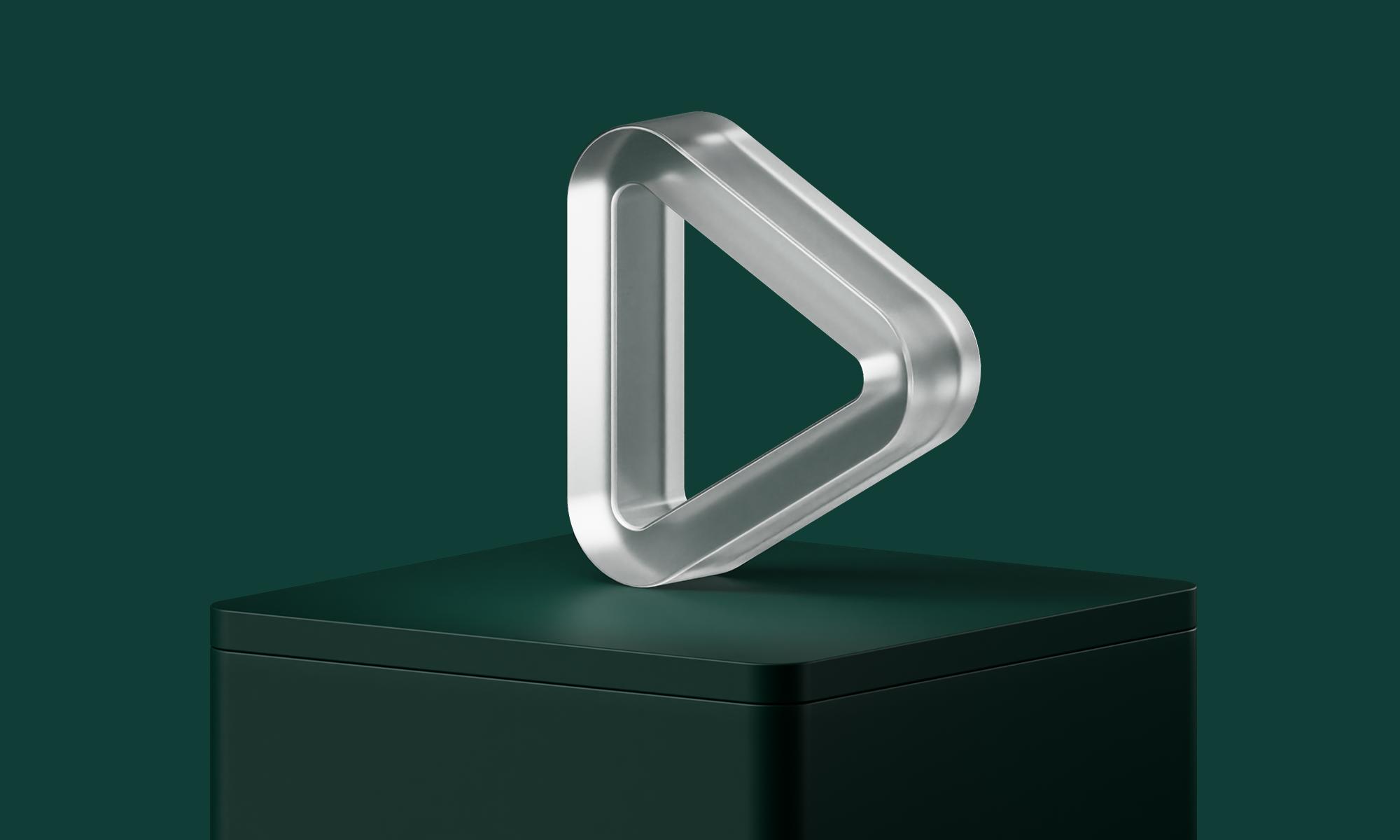 A metallic, triangular sculpture with rounded edges sits atop a dark green pedestal against a matching background.